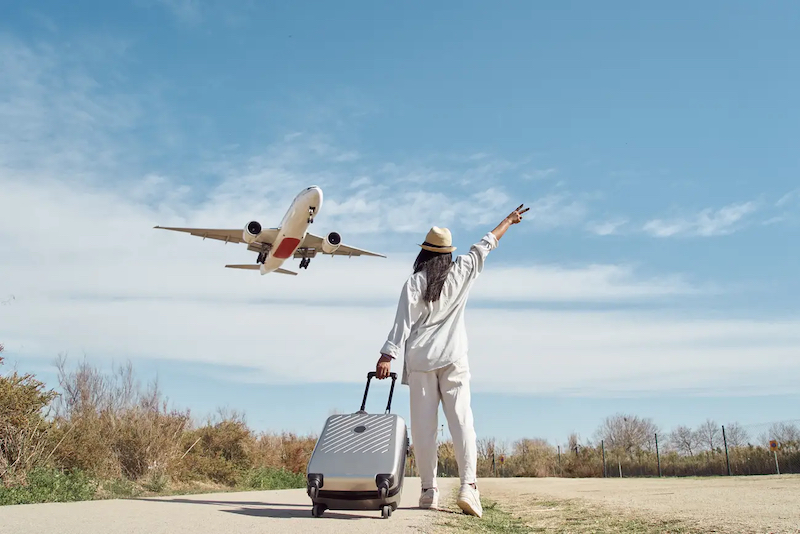 Viajante com mala e avião